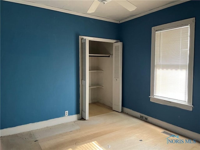 unfurnished bedroom with baseboards, a closet, ceiling fan, and crown molding