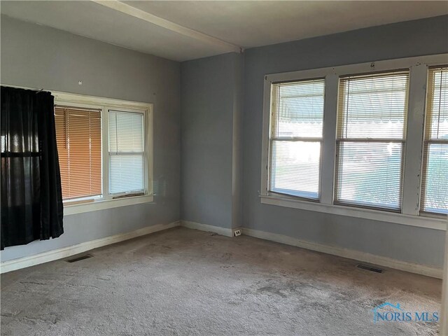 unfurnished room with visible vents, carpet flooring, and baseboards
