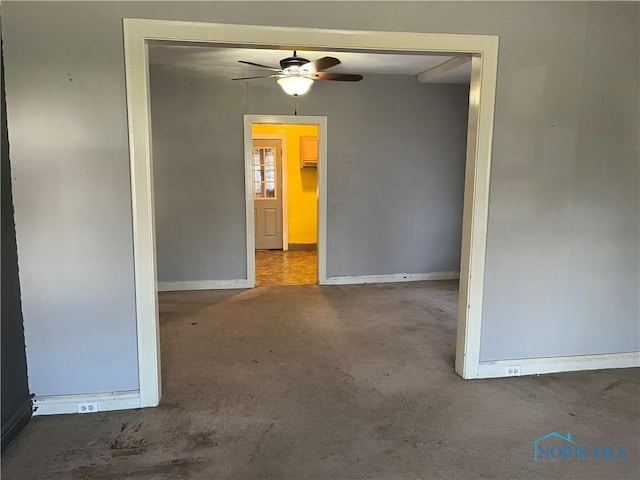 empty room featuring ceiling fan, baseboards, and carpet flooring