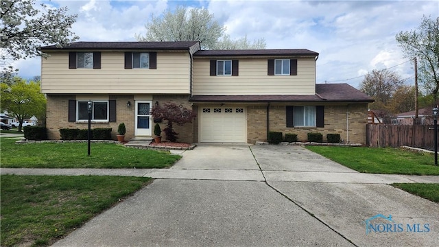 view of front of property featuring concrete driveway, a front lawn, fence, a garage, and brick siding