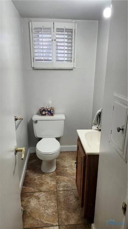 bathroom featuring baseboards, toilet, and vanity
