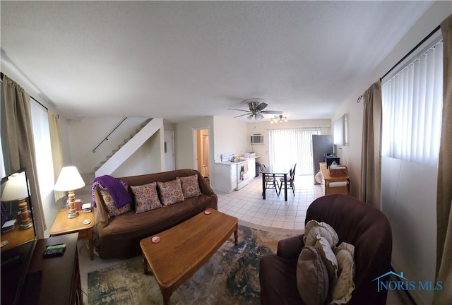 living area with a ceiling fan and stairs