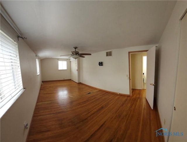 spare room featuring a ceiling fan, wood finished floors, and visible vents