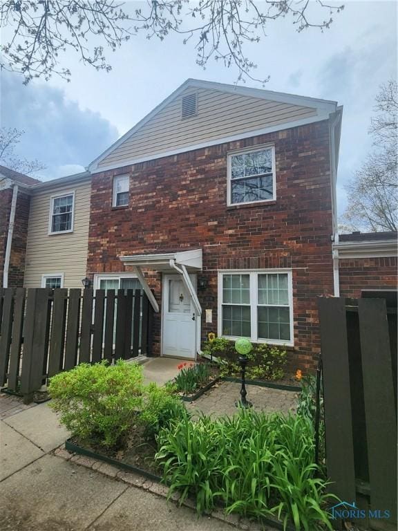 view of front of home with fence and brick siding