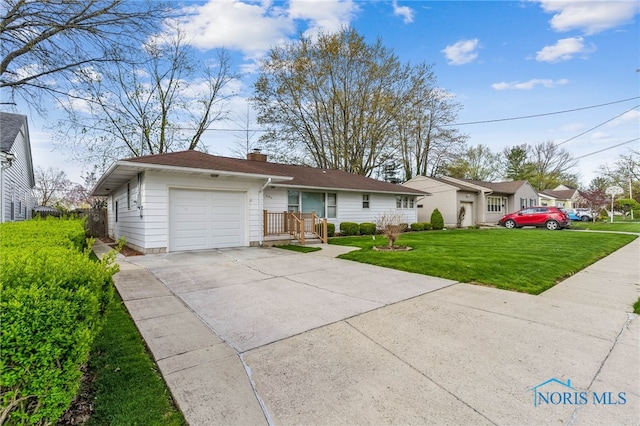 view of front of home featuring concrete driveway, a garage, a chimney, and a front yard