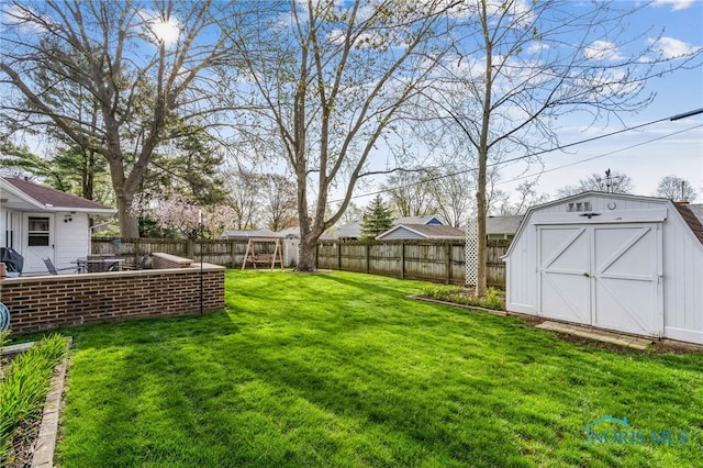 view of yard with a storage shed, an outbuilding, and a fenced backyard