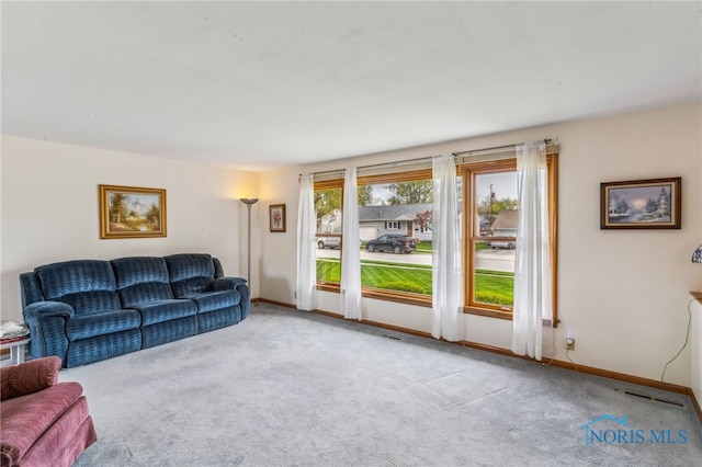 living room featuring visible vents, baseboards, and carpet flooring