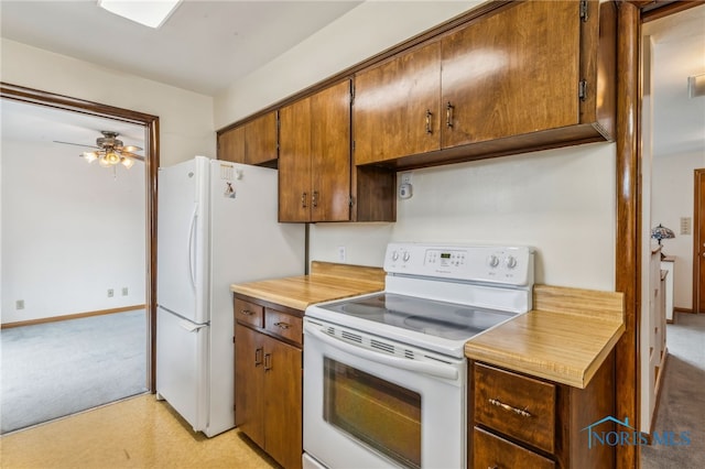 kitchen with light countertops, white appliances, baseboards, light colored carpet, and ceiling fan