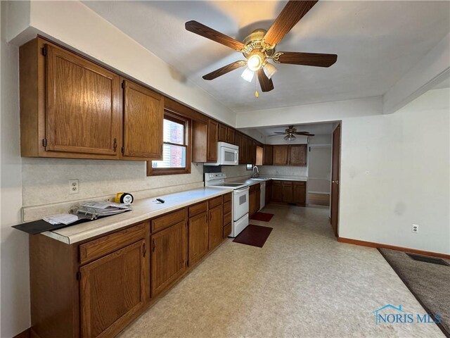 3721 Kershaw Ave, Toledo, OH 43613 - kitchen with white appliances, a sink, baseboards, and light countertops