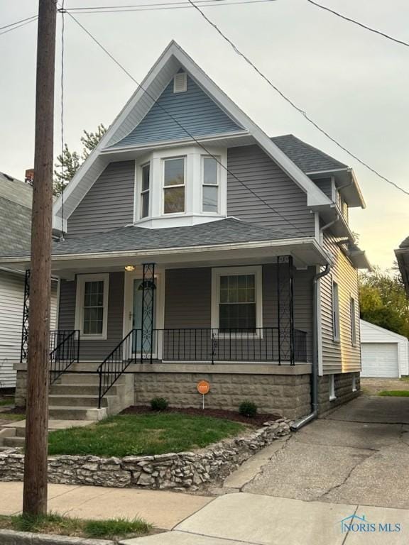 419 Spencer St, Toledo, OH 43609 - view of front of home with roof with shingles, an outbuilding, a garage, and covered porch