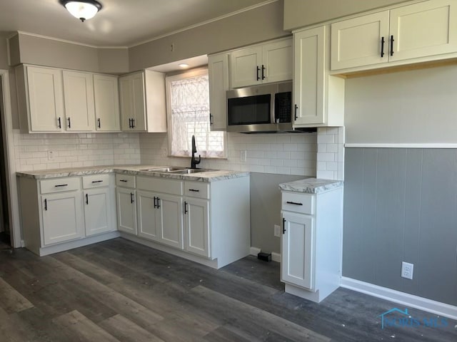 419 Spencer St, Toledo, OH 43609 - kitchen with white cabinets, backsplash, a sink, and stainless steel microwave