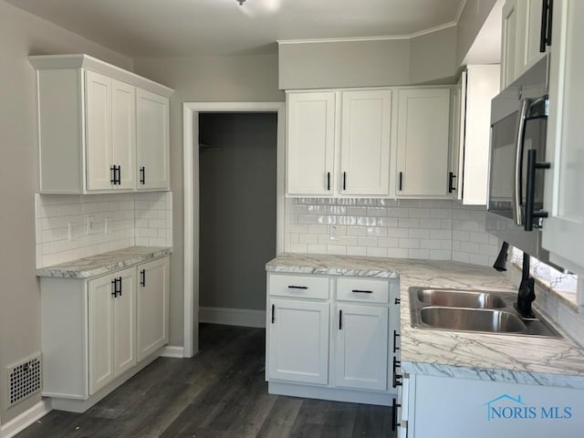 419 Spencer St, Toledo, OH 43609 - kitchen featuring a sink, light countertops, backsplash, white cabinetry, and visible vents