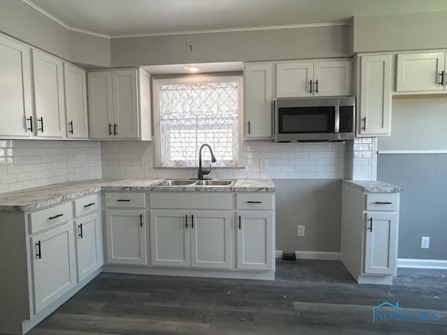 419 Spencer St, Toledo, OH 43609 - kitchen featuring stainless steel microwave, ornamental molding, a sink, and white cabinets