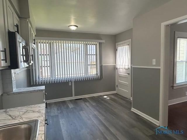 419 Spencer St, Toledo, OH 43609 - unfurnished dining area with baseboards and dark wood-style floors