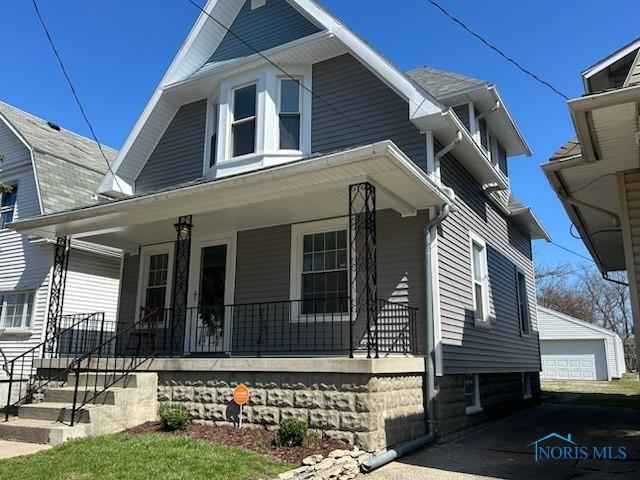 419 Spencer St, Toledo, OH 43609 - bungalow-style house featuring an outbuilding, a detached garage, and covered porch