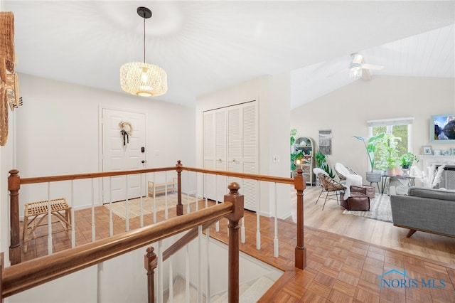 hallway featuring an upstairs landing, parquet floors, and lofted ceiling