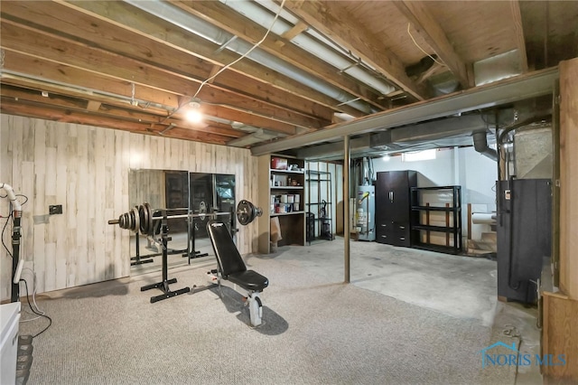 exercise area with wood walls, gas water heater, and heating unit