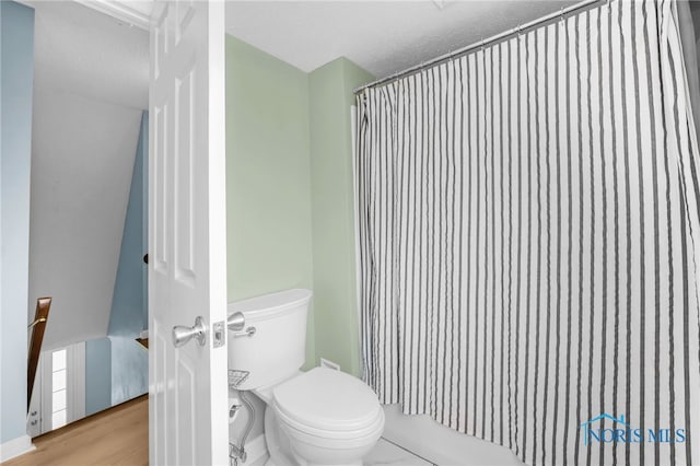 bathroom featuring wood finished floors and toilet