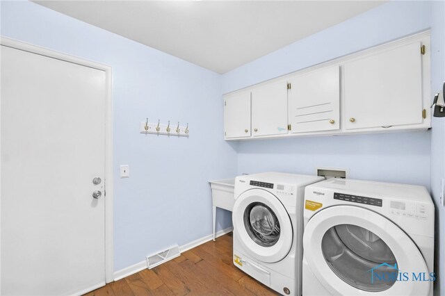 laundry area featuring baseboards, cabinet space, washing machine and clothes dryer, dark wood-style floors, and visible vents