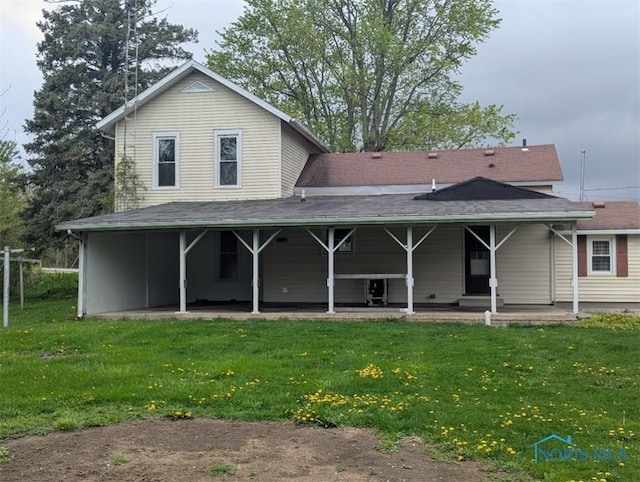back of property with a patio and a yard