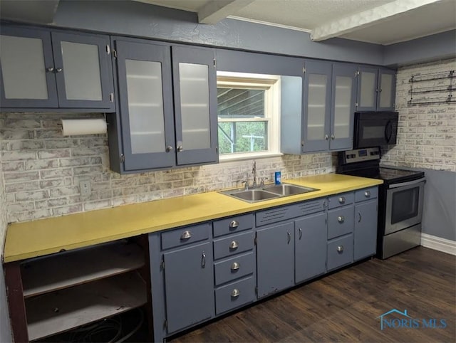 kitchen with stainless steel range with electric stovetop, black microwave, light countertops, a sink, and gray cabinetry