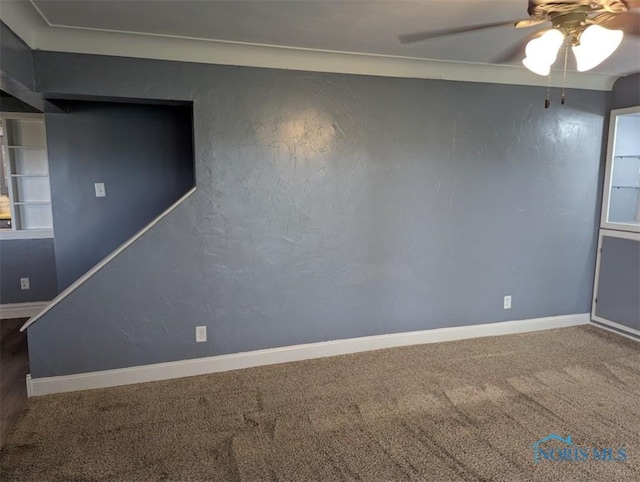 interior space featuring a ceiling fan, baseboards, and carpet