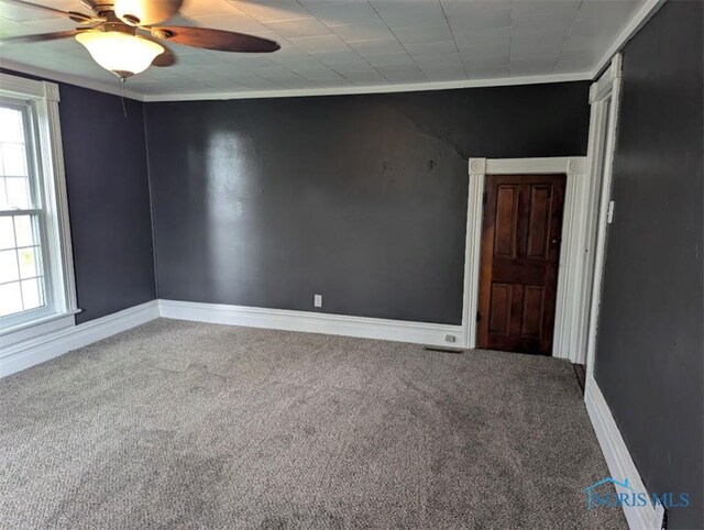 carpeted spare room with baseboards, ceiling fan, and a wealth of natural light