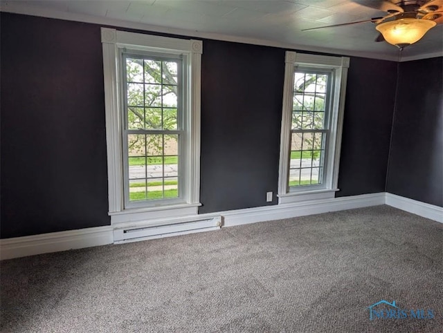 carpeted empty room with baseboards, ceiling fan, a baseboard heating unit, and a healthy amount of sunlight