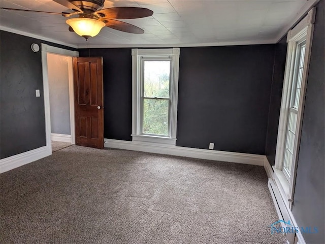 spare room featuring carpet flooring, ceiling fan, baseboards, and a baseboard radiator