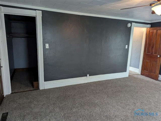 unfurnished bedroom with carpet floors, visible vents, a closet, baseboards, and ceiling fan
