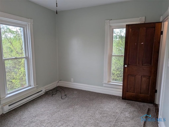 carpeted spare room with baseboards and a baseboard heating unit