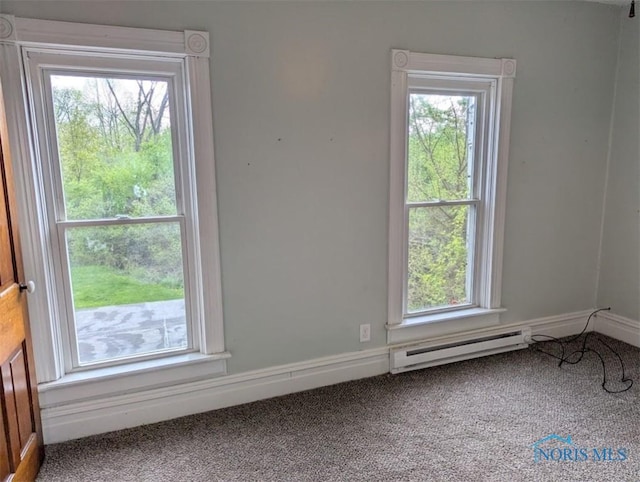 carpeted empty room featuring baseboards, plenty of natural light, and baseboard heating