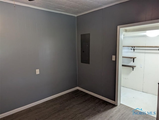 unfurnished room with ornamental molding, wood finished floors, and electric panel