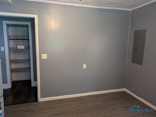 unfurnished room featuring baseboards, ornamental molding, electric panel, and dark wood finished floors