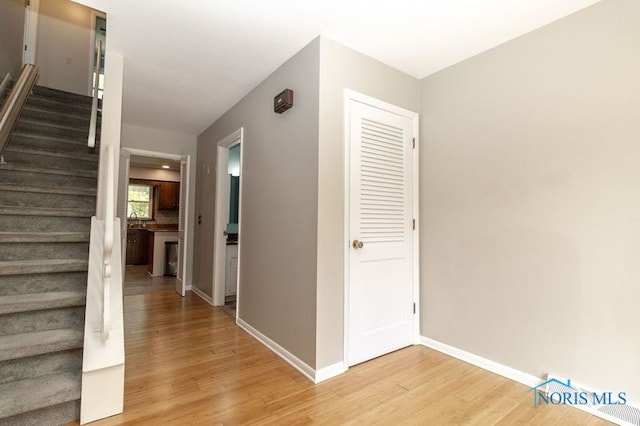 2214 Thornridge Dr, Toledo, OH 43614 - hall with stairs, light wood finished floors, and baseboards