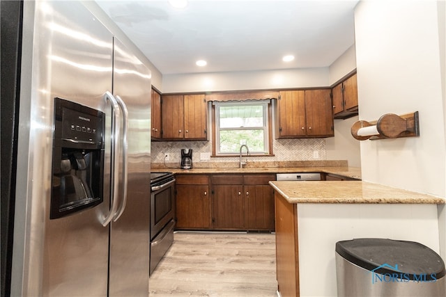 2214 Thornridge Dr, Toledo, OH 43614 - kitchen featuring appliances with stainless steel finishes, a sink, light wood-type flooring, a peninsula, and tasteful backsplash