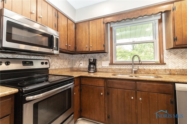 2214 Thornridge Dr, Toledo, OH 43614 - kitchen featuring appliances with stainless steel finishes, a sink, tasteful backsplash, and light countertops