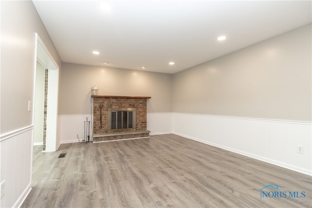 2214 Thornridge Dr, Toledo, OH 43614 - unfurnished living room featuring wood finished floors, a brick fireplace, recessed lighting, and wainscoting