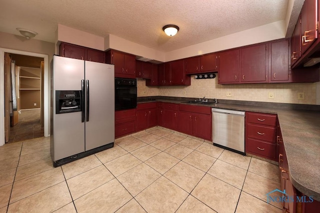 536 Edinborough Dr, Findlay, OH 45840 - kitchen with stainless steel appliances, dark countertops, a sink, a textured ceiling, and decorative backsplash