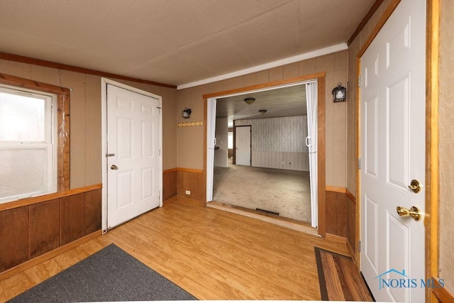 536 Edinborough Dr, Findlay, OH 45840 - foyer entrance with light wood-type flooring, wood walls, and a wainscoted wall
