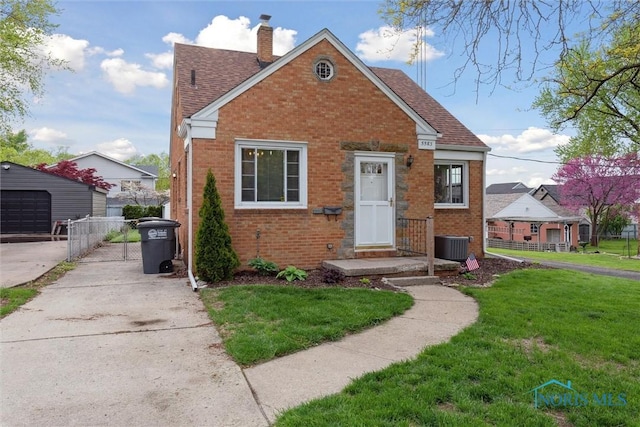 5583 304th St, Toledo, OH 43611 - view of front of house with concrete driveway, brick siding, and a front yard
