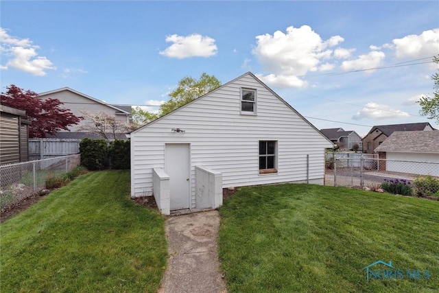 5583 304th St, Toledo, OH 43611 - rear view of property with a fenced backyard, an outdoor structure, and a lawn