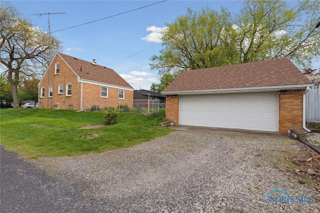 5583 304th St, Toledo, OH 43611 - view of side of property featuring fence, a detached garage, brick siding, an outbuilding, and a lawn