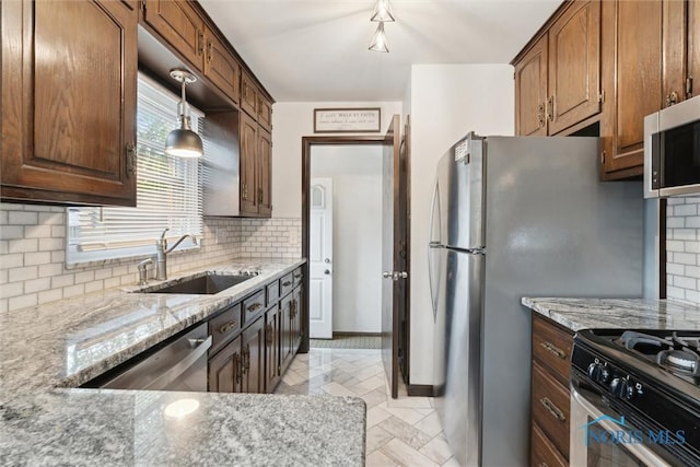 5583 304th St, Toledo, OH 43611 - kitchen with hanging light fixtures, a sink, light stone countertops, appliances with stainless steel finishes, and tasteful backsplash