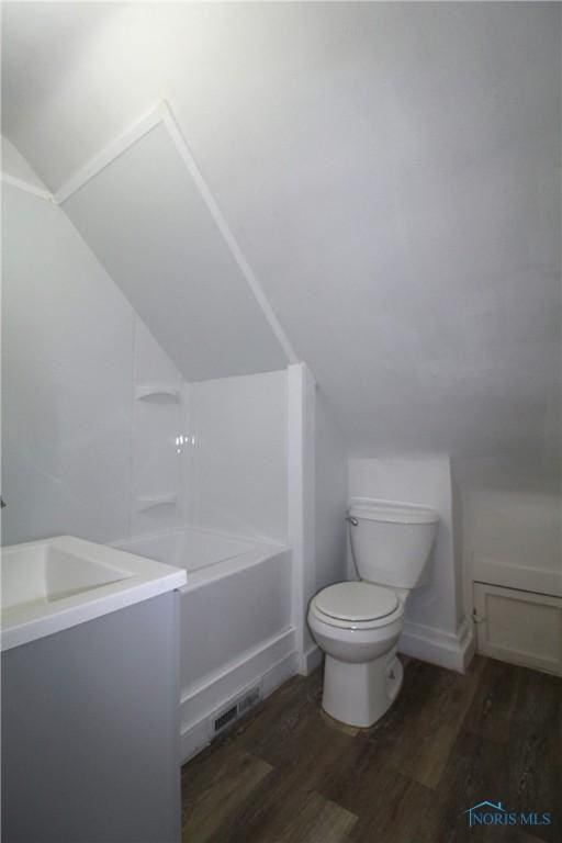 304 Dexter St, Toledo, OH 43608 - bathroom featuring toilet, vaulted ceiling, wood finished floors, vanity, and shower / tub combination