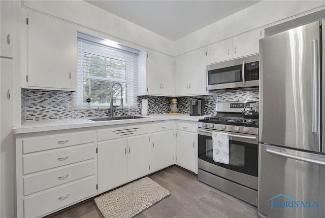 2710 131st St, Toledo, OH 43611 - kitchen featuring appliances with stainless steel finishes, a sink, light countertops, decorative backsplash, and white cabinetry