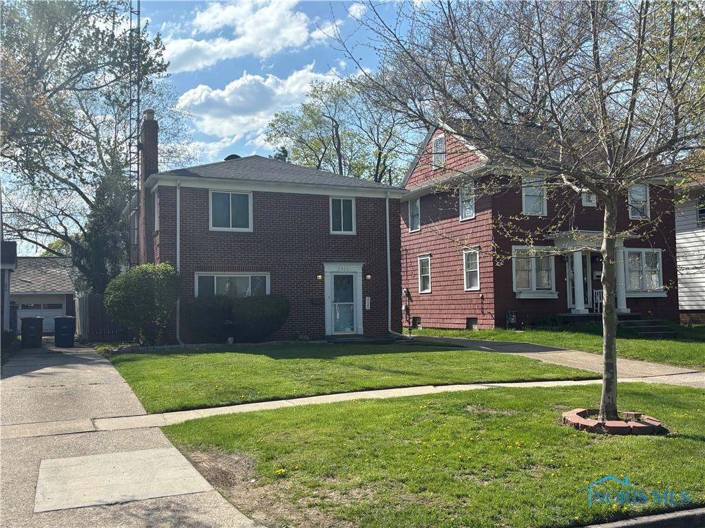 view of front of house featuring a chimney and a front yard