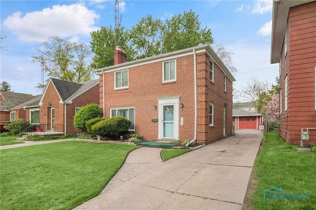 2923 Powhattan Pkwy, Toledo, OH 43606 - view of front of house featuring a chimney, brick siding, an outdoor structure, a front lawn, and a detached garage
