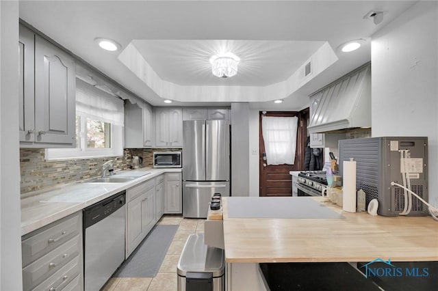 2923 Powhattan Pkwy, Toledo, OH 43606 - kitchen with stainless steel appliances, custom exhaust hood, gray cabinets, a sink, and recessed lighting