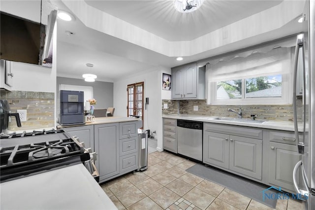 2923 Powhattan Pkwy, Toledo, OH 43606 - kitchen with stainless steel appliances, a sink, gray cabinets, light tile patterned floors, and tasteful backsplash